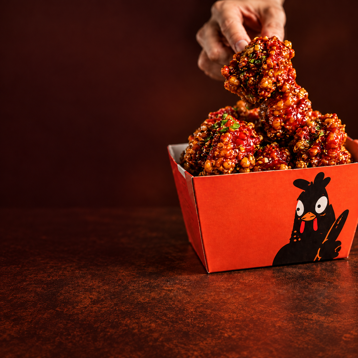 Glossy Korean fried chicken in a Kokkopi takeout box
